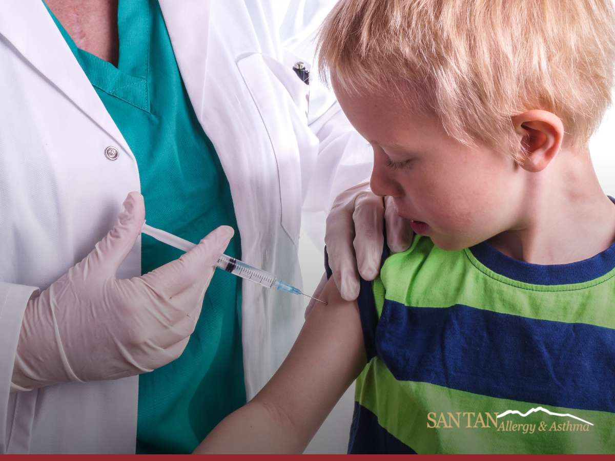 A healthcare professional administering immunotherapy to a young child wearing a striped shirt, indicative of immunotherapy for children